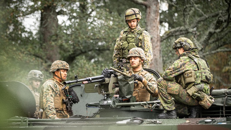 Suomalaisia ja yhdysvaltalaisia sotilaita panssarivaunun päällä.